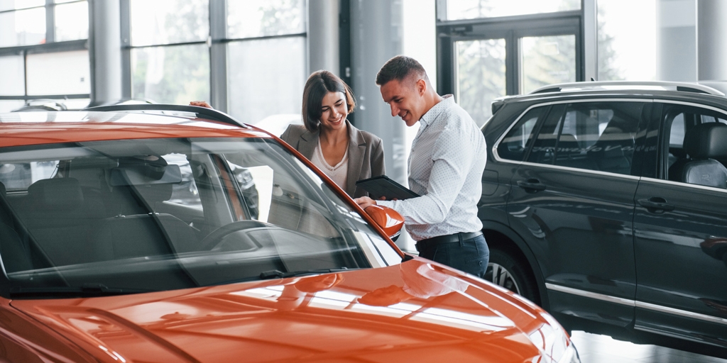 man and woman looking at a car