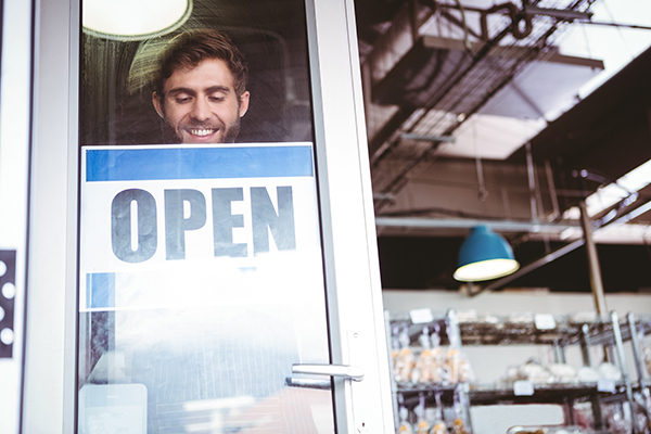 person turning over an open sign